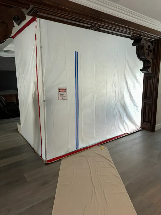 Freestanding containment barrier with plastic sheeting and zipper entry in an upscale home